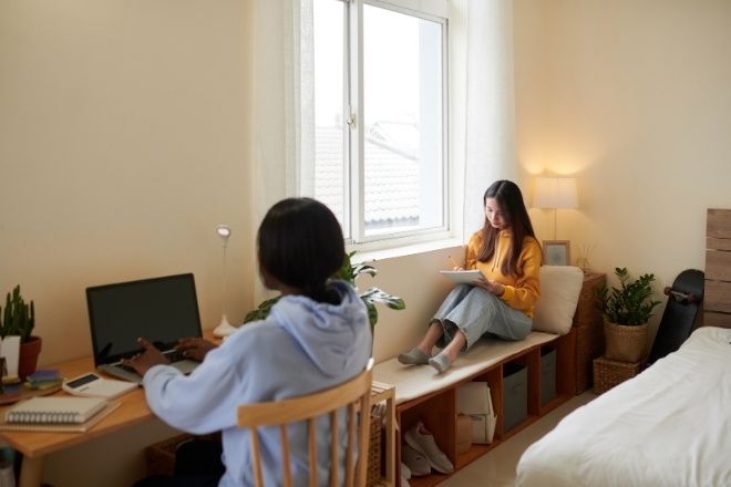 Two Female students studying in dorm.