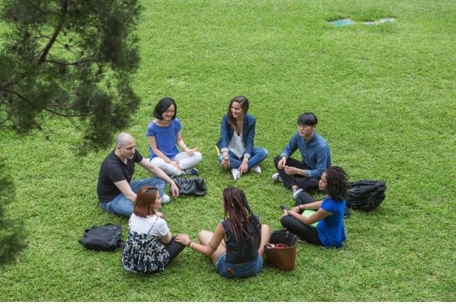 A group of people are sitting on park.