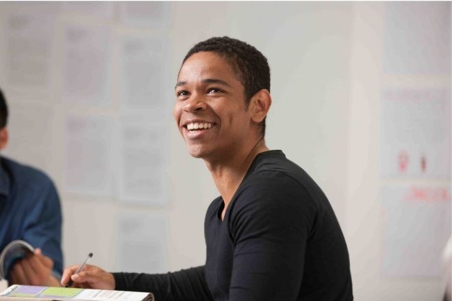 A male student is sitting in a classroom.