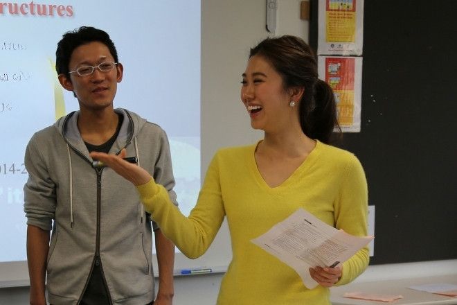 Two students are presenting in-front of the classroom.