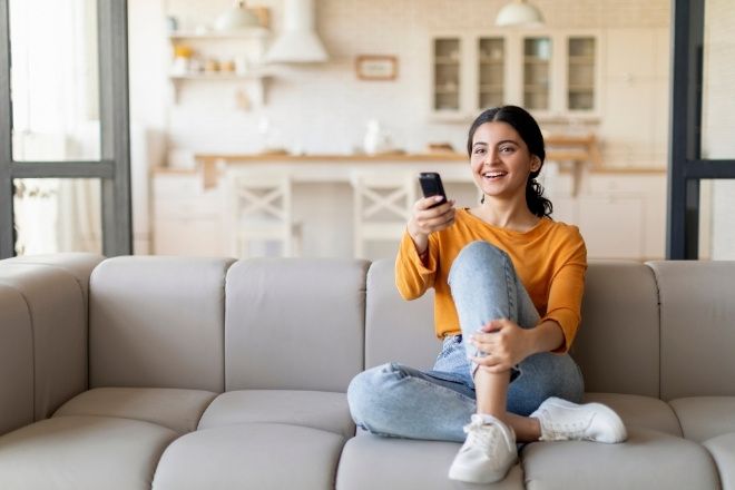 A female at home watching TV.