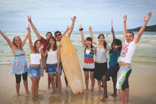 A group of people are posing on beach.