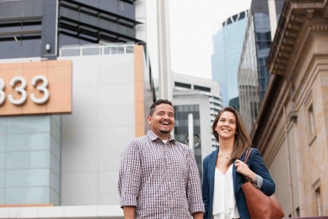 A male and female are standing outside a building.