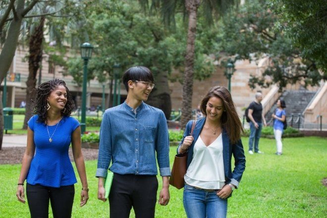Three students are walking outdoor.