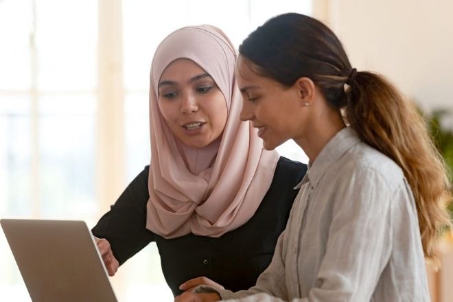 Two women are working on with a laptop.